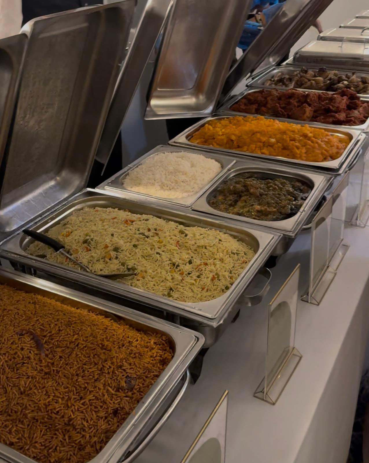 Live buffet spread with jollof rice, fried rice, curries and grilled meats